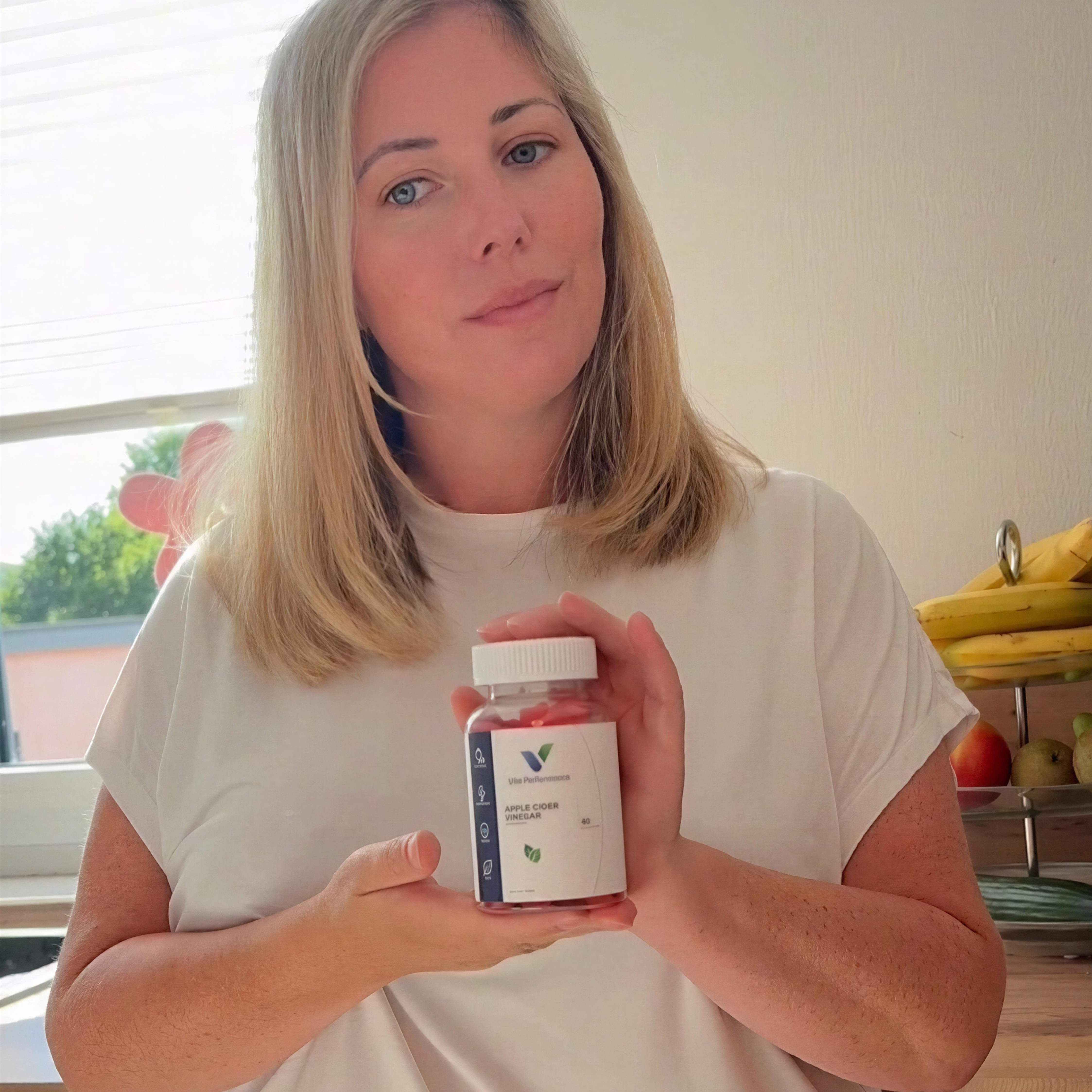 Frau mit einer Dose Vita Performance Apfelessig-Gummies